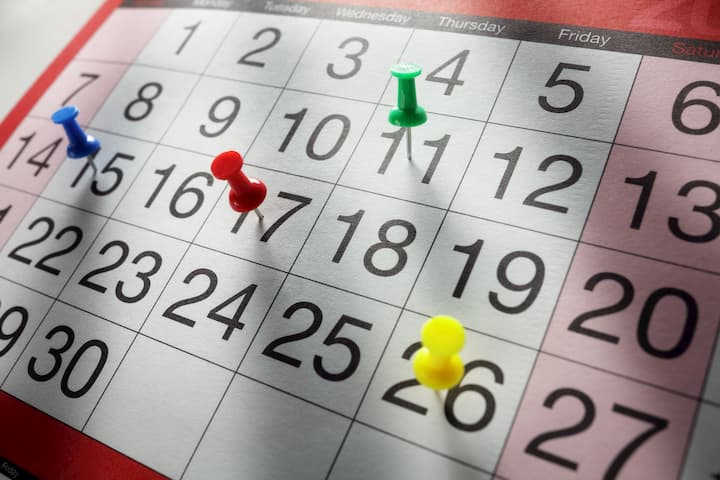 calendário com diversas datas fixadas com pinos